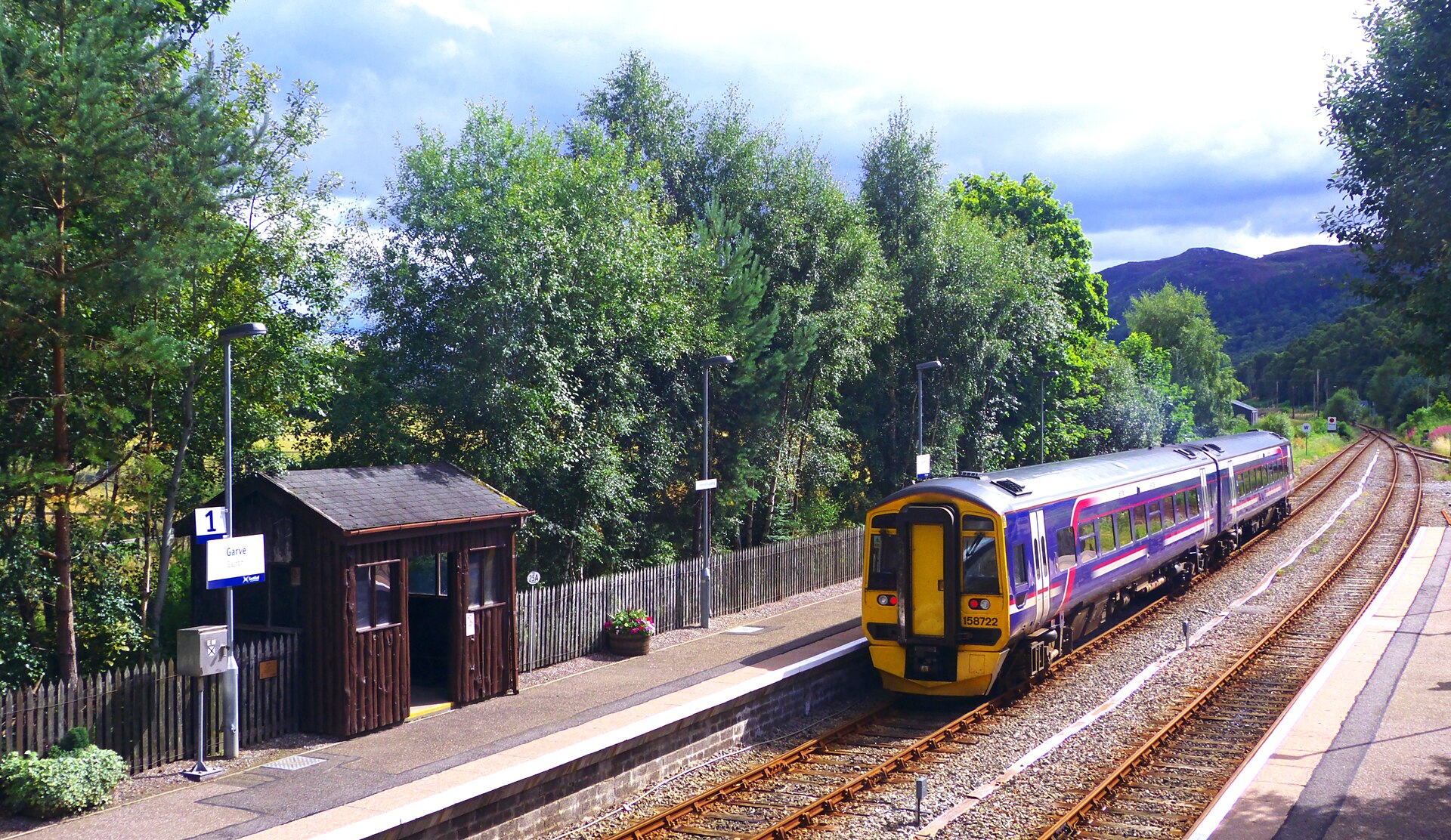 A train at a quiet station in the Scottish Highlands.